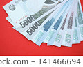 North Korean won money bills in big amount lies on red color table close up 141466694