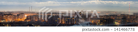 Panorama of night aerial view of Ivano-Frankivsk city, Ukraine. Scene of modern night city with bright lights of tall buildings. Residential quaters and construction cranes in modern urban space. 141466778