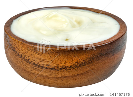 Fresh thick white Greek yogurt or sour cream in a rustic round wooden bowl isolated. Creamy texture ideal for healthy breakfast, cooking, and dairy product concepts. Fresh thick white Greek yogurt or sour cream in a rustic round wooden bowl isolated. Creamy texture ideal for healthy breakfast, cooking, and dairy product concepts. 141467176