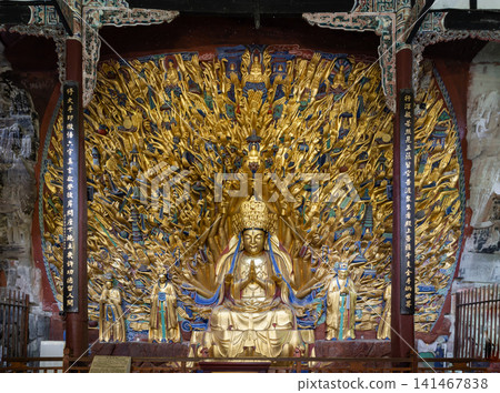 Symmetrical front view of the legendary Thousand-Hand Guanyin carved directly into the cliff cavern at Dazu, Chongqing. Adorned in brilliant gold leaf Symmetrical front view of the legendary Thousand-Hand Guanyin carved directly into the cliff cavern at Dazu, Chongqing. Adorned in brilliant gold leaf 141467838