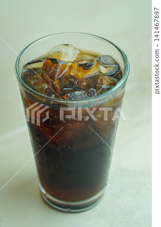 top view closeup cool and fresh dark-colored drink with ice in a clear glass, placed on a concrete surface background, food, drink, object, decor, decoration, copy space top view closeup cool and fresh dark-colored drink with ice in a clear glass, placed on a concrete surface background, food, drink, object, decor, decoration, copy space 141467897