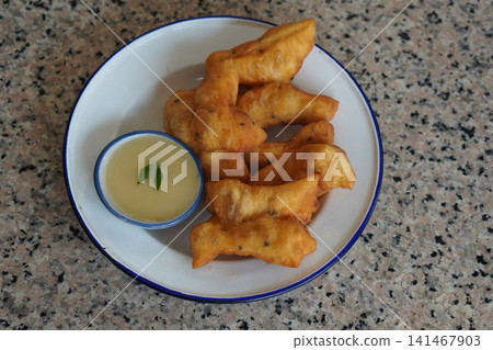 top view hot four pieces of patongko and condensed milk in a ceramic cup, placed on a white and blue enamel plate on a marble surface background, food, dessert, copy space top view hot four pieces of patongko and condensed milk in a ceramic cup, placed on a white and blue enamel plate on a marble surface background, food, dessert, copy space 141467903