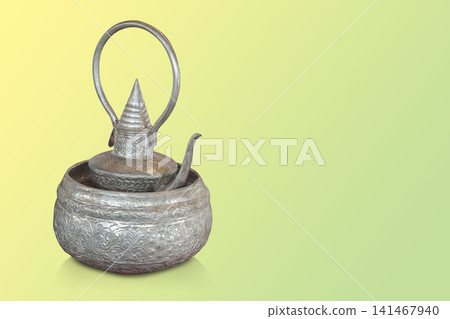 closeup antique silver kettle placed in a antique silver bowl on gradient yellow and green background, object, decor, fashion, collection, ancient, old, copy space closeup antique silver kettle placed in a antique silver bowl on gradient yellow and green background, object, decor, fashion, collection, ancient, old, copy space 141467940