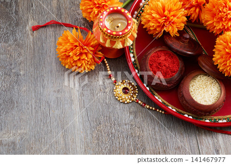 Raksha bandhan thali with rakhi, kumkum, rice, marigolds, and diya Raksha bandhan thali with rakhi, kumkum, rice, marigolds, and diya 141467977