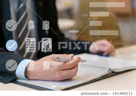 高效率的任務和文件管理:一位商務人士正在做筆記;無紙化辦公室的象徵。 高效率的任務和文件管理:一位商務人士正在做筆記;無紙化辦公室的象徵。 141468111