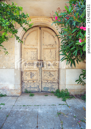 Old wooden arched door with flowers at Dajla Monastery, Croatia. Old wooden arched door with flowers at Dajla Monastery, Croatia. 141468181