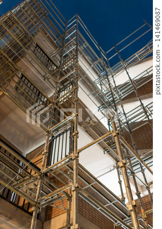 Metal scaffolding erected during large-scale renovation work on an apartment building at night. 141469087