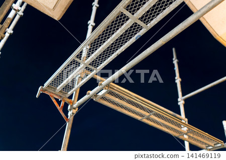 Night view of an apartment building undergoing large-scale repair work to address aging infrastructure. Night view of an apartment building undergoing large-scale repair work to address aging infrastructure. 141469119