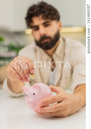 Indian man holding small piggy bank coin saving money dream about future personal savings big budget 141469387