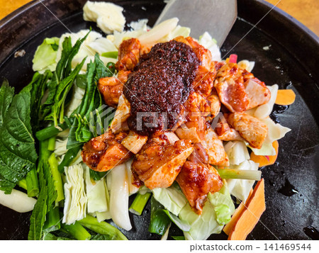 Spicy Korean Chicken Stir Fry Dakgalbi with Vegetables on Iron Pan Spicy Korean Chicken Stir Fry Dakgalbi with Vegetables on Iron Pan 141469544
