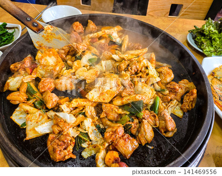 Spicy Korean Chicken Stir Fry Dakgalbi with Vegetables on Iron Pan Spicy Korean Chicken Stir Fry Dakgalbi with Vegetables on Iron Pan 141469556