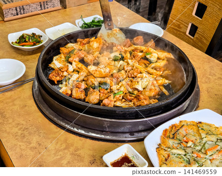 Spicy Korean Chicken Stir Fry Dakgalbi with Vegetables on Iron Pan Spicy Korean Chicken Stir Fry Dakgalbi with Vegetables on Iron Pan 141469559
