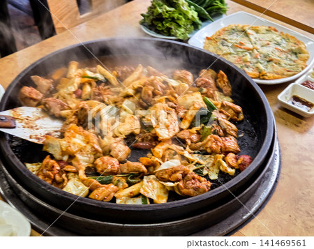 Spicy Korean Chicken Stir Fry Dakgalbi with Vegetables on Iron Pan Spicy Korean Chicken Stir Fry Dakgalbi with Vegetables on Iron Pan 141469561