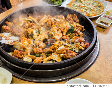 Spicy Korean Chicken Stir Fry Dakgalbi with Vegetables on Iron Pan Spicy Korean Chicken Stir Fry Dakgalbi with Vegetables on Iron Pan 141469562