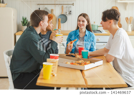 Home party. Friends spending time together having fun laughing communicating at home. Happy diverse group eating pizza drinking beer or lemonade. Mixed race young buddies best friends enjoying weekend Home party. Friends spending time together having fun laughing communicating at home. Happy diverse group eating pizza drinking beer or lemonade. Mixed race young buddies best friends enjoying weekend 141469637