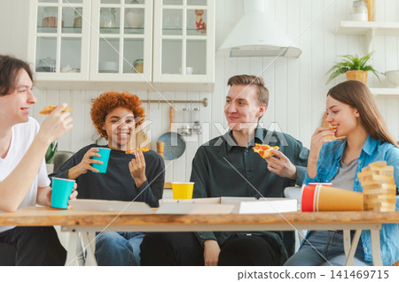 Home party. Friends spending time together having fun laughing communicating at home. Happy diverse group eating pizza drinking beer or lemonade. Mixed race young buddies best friends enjoying weekend Home party. Friends spending time together having fun laughing communicating at home. Happy diverse group eating pizza drinking beer or lemonade. Mixed race young buddies best friends enjoying weekend 141469715