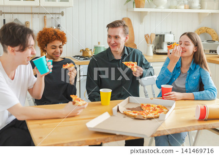 Home party. Friends spending time together having fun laughing communicating at home. Happy diverse group eating pizza drinking beer or lemonade. Mixed race young buddies best friends enjoying weekend Home party. Friends spending time together having fun laughing communicating at home. Happy diverse group eating pizza drinking beer or lemonade. Mixed race young buddies best friends enjoying weekend 141469716