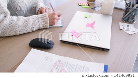 Work routine. Secretary desk. Unrecognizable female entrepreneur in office with paperwork laptop planning professional lifestyle. Work routine. Secretary desk. Unrecognizable female entrepreneur in office with paperwork laptop planning professional lifestyle. 141469981