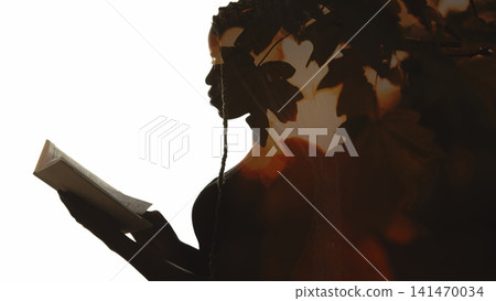 Reading inspiration. Autumn study. Double exposure foliage lens flare profile silhouette of woman with open book isolated on white copy space. Reading inspiration. Autumn study. Double exposure foliage lens flare profile silhouette of woman with open book isolated on white copy space. 141470034