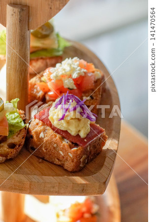 Rustic Gourmet Canapes with Fresh Tomato Cheese and Herbs on Artisan Bread Served on Wooden Stand Close Up Appetizer Finger Food for Brunch Catering Cafe Restaurant Menu Rustic Gourmet Canapes with Fresh Tomato Cheese and Herbs on Artisan Bread Served on Wooden Stand Close Up Appetizer Finger Food for Brunch Catering Cafe Restaurant Menu 141470564