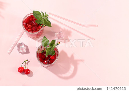 Modern still life with berry juice, raspberries, cherries, red currants, and ice on an elegant kitchen table, casting long, sharp shadows. The concept is a minimal detox diet, summer vitamin drinks Modern still life with berry juice, raspberries, cherries, red currants, and ice on an elegant kitchen table, casting long, sharp shadows. The concept is a minimal detox diet, summer vitamin drinks 141470613