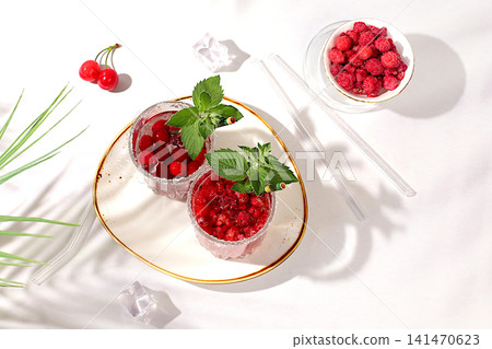 Detox water with raspberries, cherries, and currants, over ice. A refreshing summer homemade lemonade cocktail. Fruit juice and ingredients, weight loss concepts, healthy and natural food, mojito Detox water with raspberries, cherries, and currants, over ice. A refreshing summer homemade lemonade cocktail. Fruit juice and ingredients, weight loss concepts, healthy and natural food, mojito 141470623