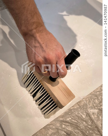 Applying primer or adhesive to the surface using a wide block brush. Applying primer or adhesive to the surface using a wide block brush. 141470987