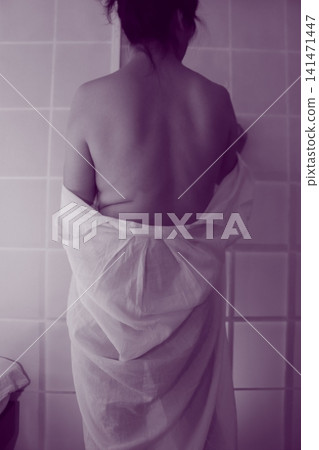 一位女士脫下白襯衫,露出了她的背影。 一位女士脫下白襯衫,露出了她的背影。 141471447