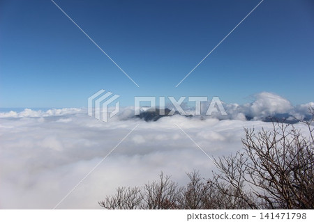 A magnificent mountain landscape of Mt. Kamegamori, set against a vast sea of clouds and a clear blue sky, as seen from Mt. Ishizuchi in Ehime Prefecture. 141471798