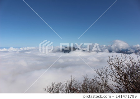 A magnificent mountain landscape of Mt. Kamegamori, set against a vast sea of clouds and a clear blue sky, as seen from Mt. Ishizuchi in Ehime Prefecture. 141471799