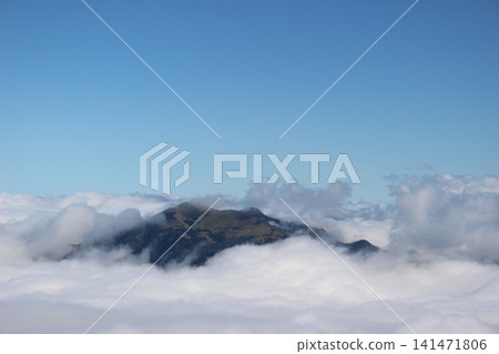 A magnificent mountain landscape of Mt. Kamegamori, set against a vast sea of clouds and a clear blue sky, as seen from Mt. Ishizuchi in Ehime Prefecture. 141471806