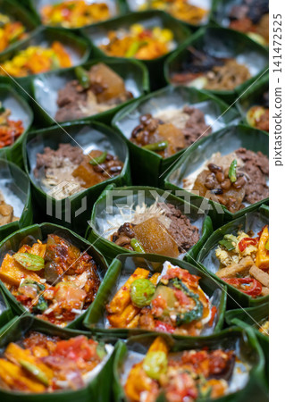 Traditional Indonesian Rice Served in Banana Leaf Takir with Assorted Toppings on Bamboo Tray, Homemade Catering Meals, Authentic Nusantara Cuisine, Eco Friendly Food Presentation Traditional Indonesian Rice Served in Banana Leaf Takir with Assorted Toppings on Bamboo Tray, Homemade Catering Meals, Authentic Nusantara Cuisine, Eco Friendly Food Presentation 141472525