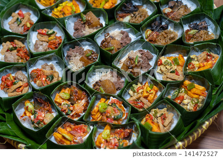 Traditional Indonesian Rice Served in Banana Leaf Takir with Assorted Toppings on Bamboo Tray, Homemade Catering Meals, Authentic Nusantara Cuisine, Eco Friendly Food Presentation Traditional Indonesian Rice Served in Banana Leaf Takir with Assorted Toppings on Bamboo Tray, Homemade Catering Meals, Authentic Nusantara Cuisine, Eco Friendly Food Presentation 141472527