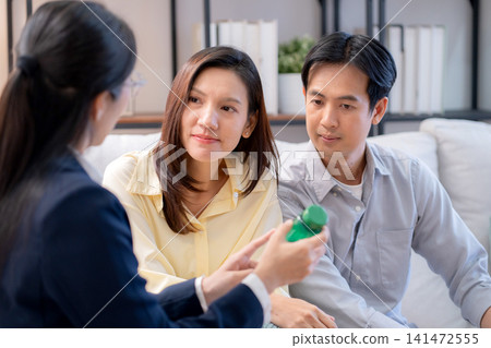 Asian young couple on sofa consulting with psychologist in living room at home. Asian young couple on sofa consulting with psychologist in living room at home. 141472555
