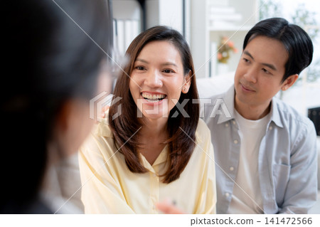 Asian couple sitting on sofa consulting with psychologist for marriage therapy mental health. Asian couple sitting on sofa consulting with psychologist for marriage therapy mental health. 141472566