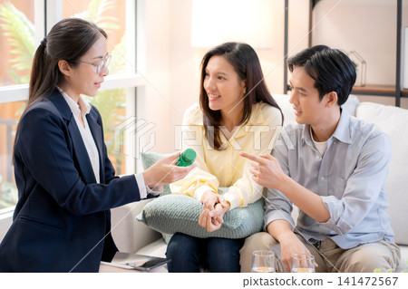 Asian young couple on sofa consulting with psychologist in living room at home. Asian young couple on sofa consulting with psychologist in living room at home. 141472567