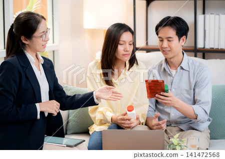 Asian young couple on sofa consulting with psychologist in living room at home. Asian young couple on sofa consulting with psychologist in living room at home. 141472568