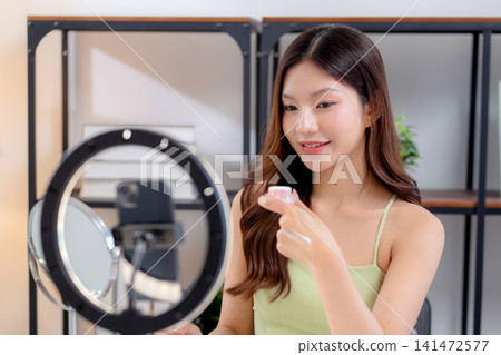 Young asian woman presenting and review cosmetic product with on social media. Young asian woman presenting and review cosmetic product with on social media. 141472577