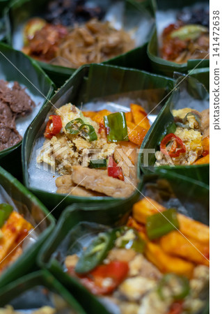 Traditional Indonesian Rice Meal in Banana Leaf Takir with Spicy Tofu, Tempeh, Egg and Sambal, Authentic Nusantara Cuisine, Eco Friendly Food Packaging and Homemade Catering Traditional Indonesian Rice Meal in Banana Leaf Takir with Spicy Tofu, Tempeh, Egg and Sambal, Authentic Nusantara Cuisine, Eco Friendly Food Packaging and Homemade Catering 141472638