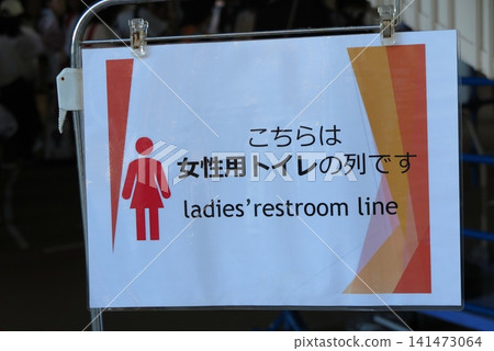 A signpost at the end of the crowded line for the women's restroom. A signpost at the end of the crowded line for the women's restroom. 141473064