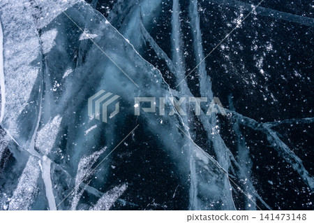 High angle view of cracks surface of the frozen lake of Baikal lake with frost methane bubbles in winter season. Baikal is the largest freshwater lake and the world's deepest lake. High angle view of cracks surface of the frozen lake of Baikal lake with frost methane bubbles in winter season. Baikal is the largest freshwater lake and the world's deepest lake. 141473148