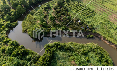 Aerial view of river flowing through abundance landscape in rural area of Chiang Rai province of Thailand. Aerial view of river flowing through abundance landscape in rural area of Chiang Rai province of Thailand. 141473150