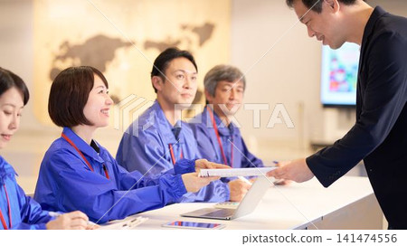 Staff assisting visitors at the event venue reception. Staff assisting visitors at the event venue reception. 141474556