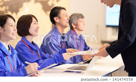 Staff assisting visitors at the event venue reception. Staff assisting visitors at the event venue reception. 141474559