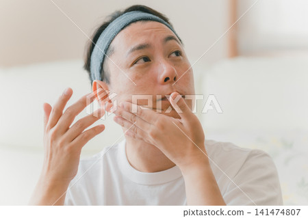 A man in his 40s wearing a hair turban to care for his face. A man in his 40s wearing a hair turban to care for his face. 141474807