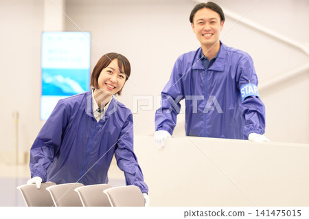 活動現場有兩名工作人員,一男一女,面帶微笑。 活動現場有兩名工作人員,一男一女,面帶微笑。 141475015