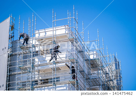 Construction site, wedge scaffolding, scaffolding assembly, open sky, workers, teamwork, coordination Construction site, wedge scaffolding, scaffolding assembly, open sky, workers, teamwork, coordination 141475462