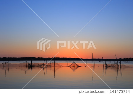 Morning glow reflected on the water surface Morning glow reflected on the water surface 141475754