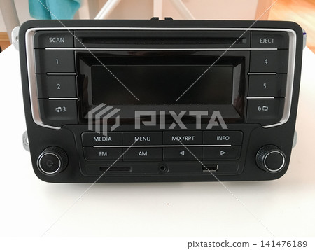 Front view of a Volkswagen car radio with media menu and FM AM control buttons. Front view of a Volkswagen car radio with media menu and FM AM control buttons. 141476189