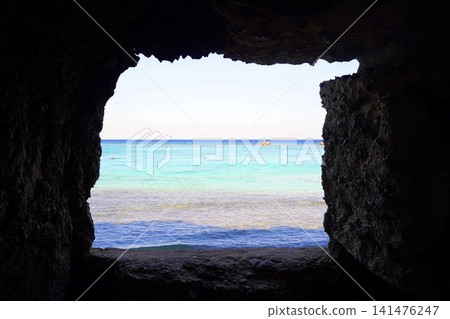The emerald green sea and the horizon as seen from the cave window. 141476247